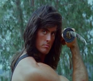 A white guy with long hair weilding a Katana, an image so 90's you can taste it.